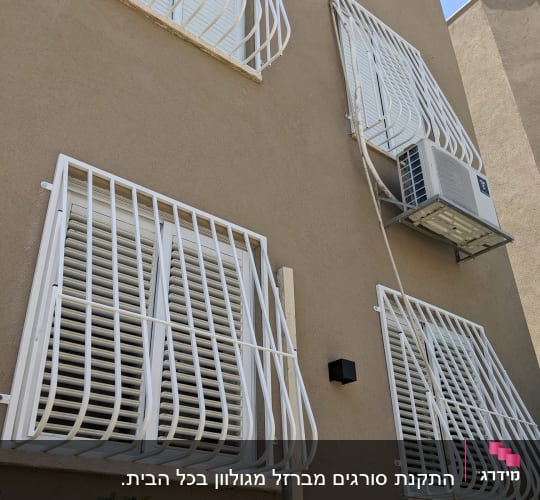 סורגים עם בטן מברזל בצבע לבן המותקנים על חלונות בית